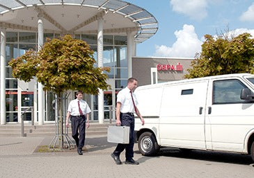 Agent de sécurité orfix manipulant des sacs de transport de fonds hautement sécurisés.